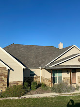 Dark architectural shingle roof on a stone home